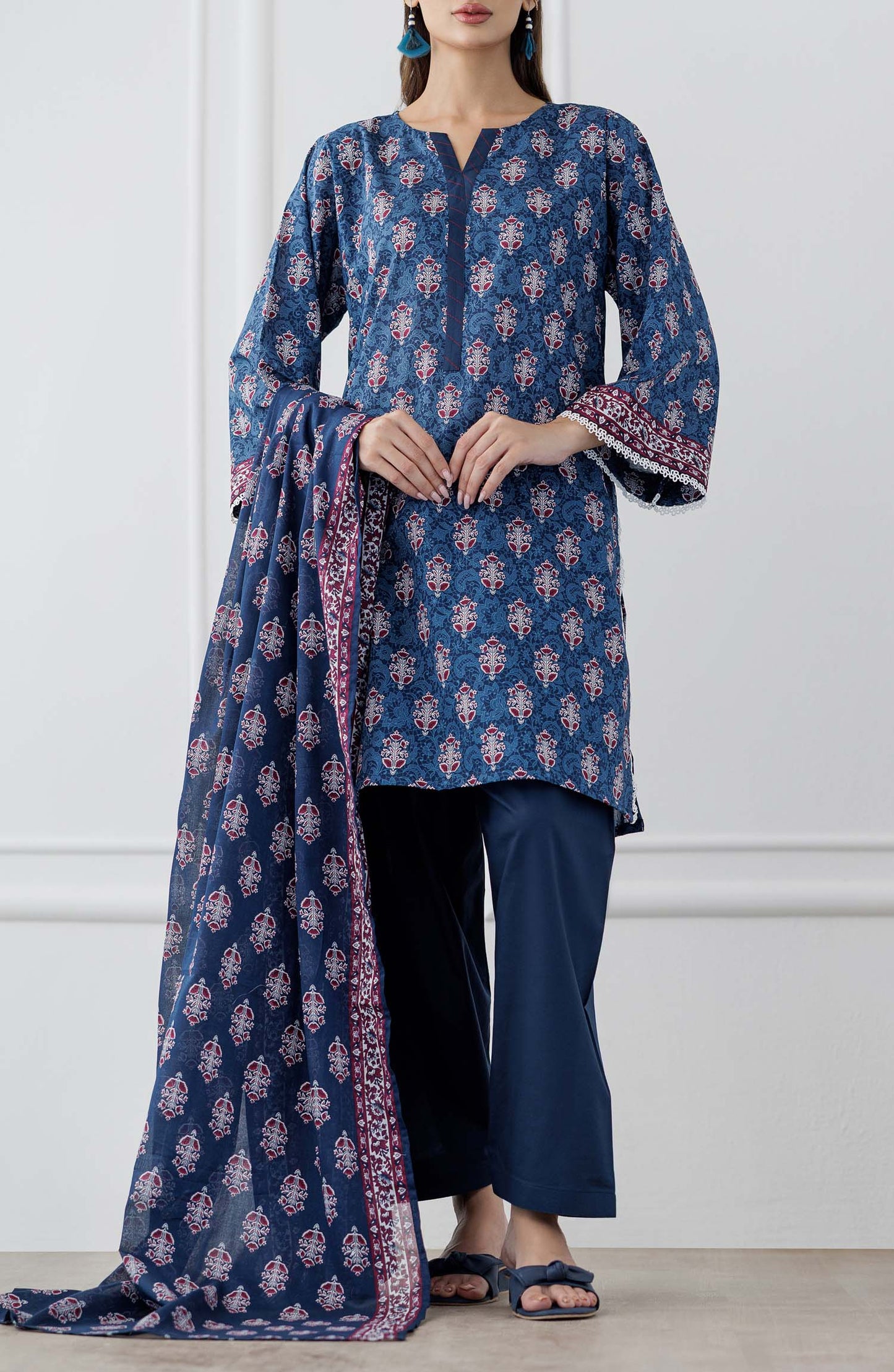 UNSTITCHED Printed Lawn Shirt Dupatta & Pant - 3 Piece Suits - OTL-25-353. Woman wearing a blue patterned kurta with matching pants and a dupatta against a plain trouser.