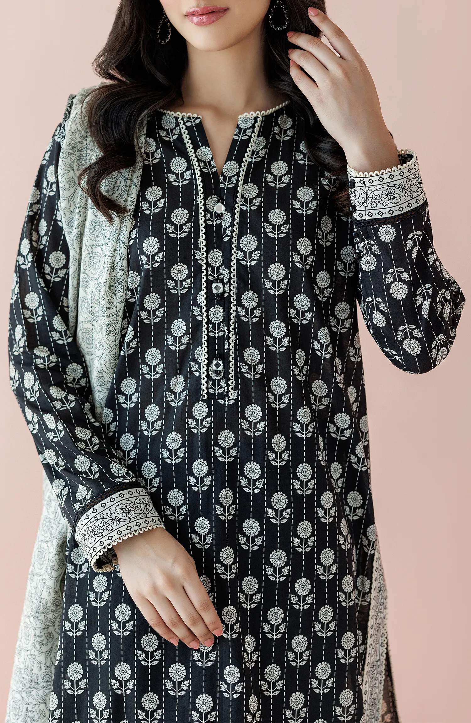 Woman wearing a black floral kurta with black pants and a light gray dupatta on a plain black trouser. Unstitched Printed Lawn Shirt Dupatta & Pant - 3 Piece Suits - OTL-20025