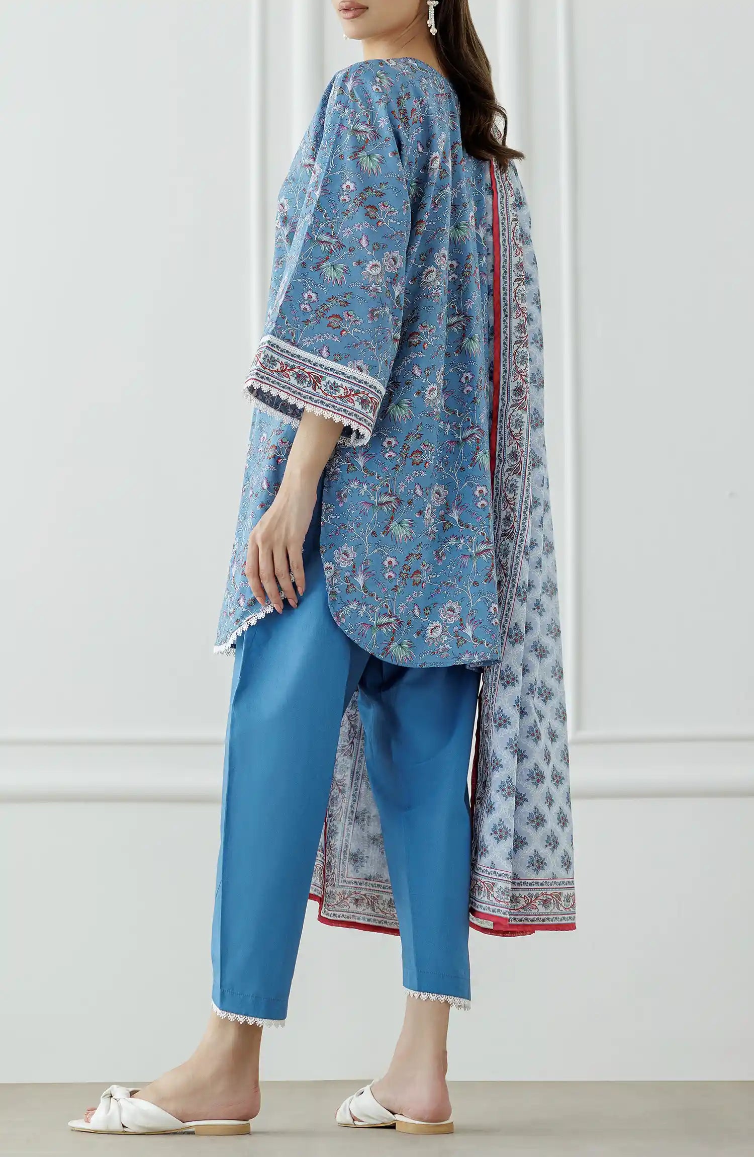 Woman wearing a blue traditional outfit with a dyed shalwar. Stitched Printed Lawn Shirt Dupatta & Pant - 3 Piece - OTL-25-333.