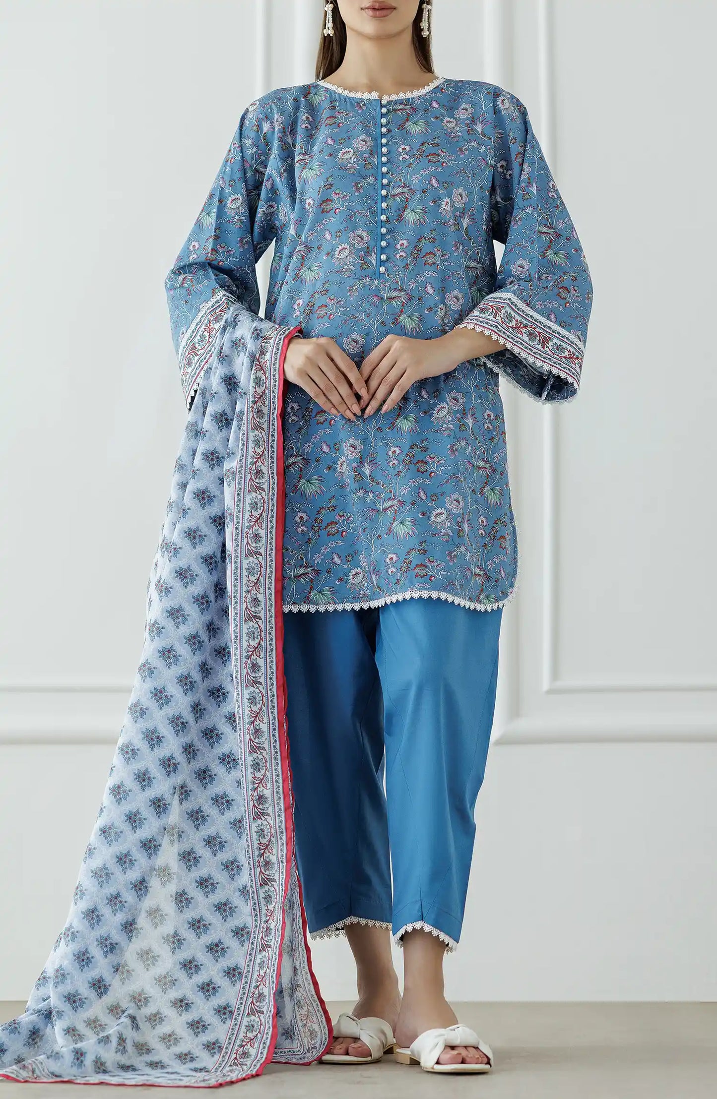 Woman wearing a blue traditional outfit with a dyed shalwar. Stitched Printed Lawn Shirt Dupatta & Pant - 3 Piece - OTL-25-333.