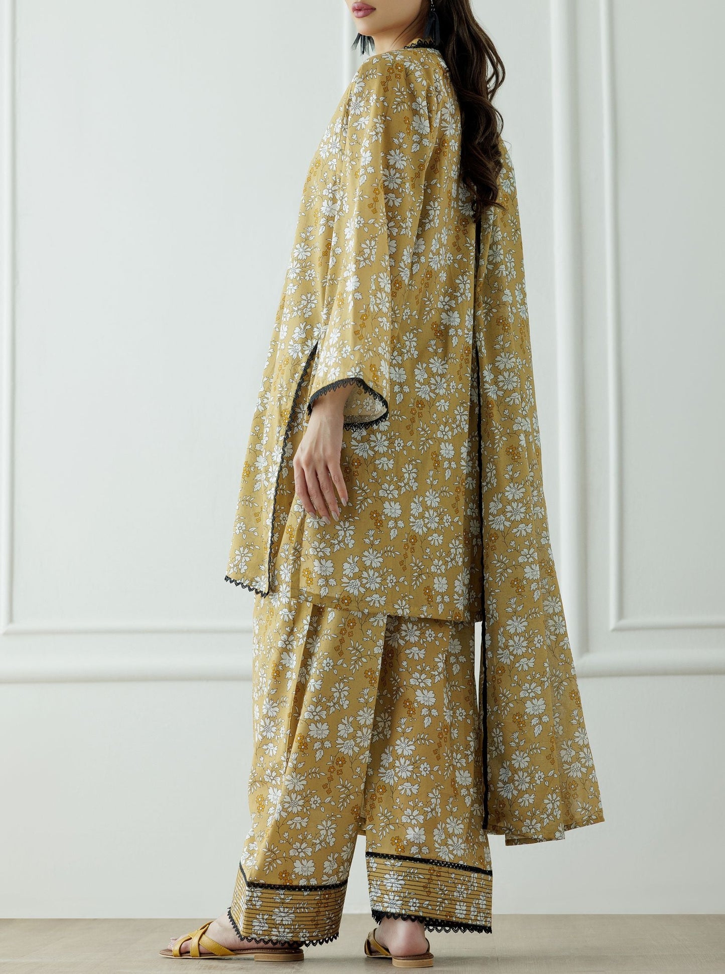 Stitched Printed Lawn Shirt Dupatta & Pant - 3 Piece - OTL-25-067. Woman wearing a mustard yellow floral dress with black lace trim.