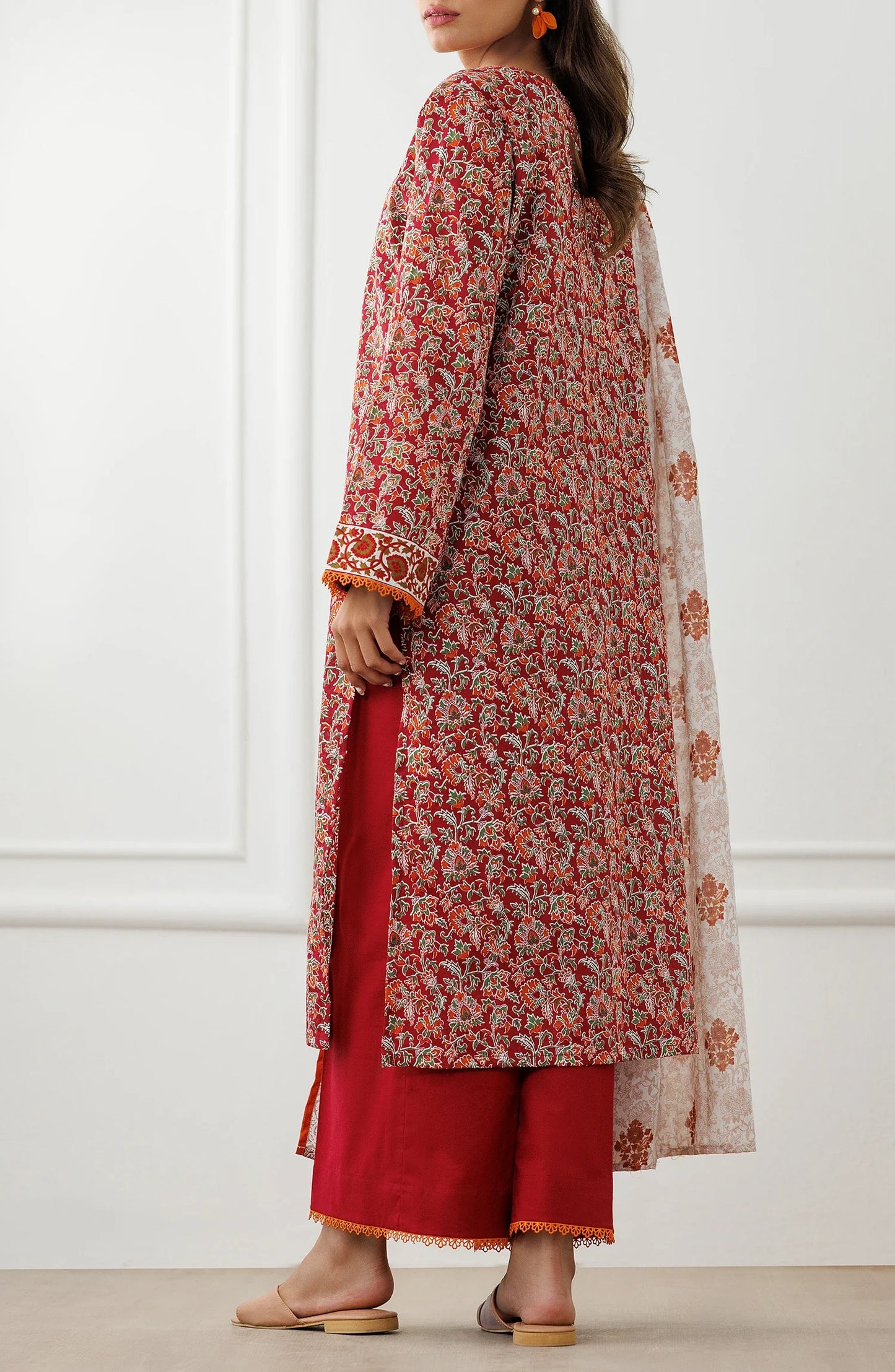 Woman wearing a red floral dress with matching pants and a white dupatta in a dyed trouser. Unstitched Printed Lawn Shirt Dupatta & Pant - 3 Piece Suits - OTL-25-096
