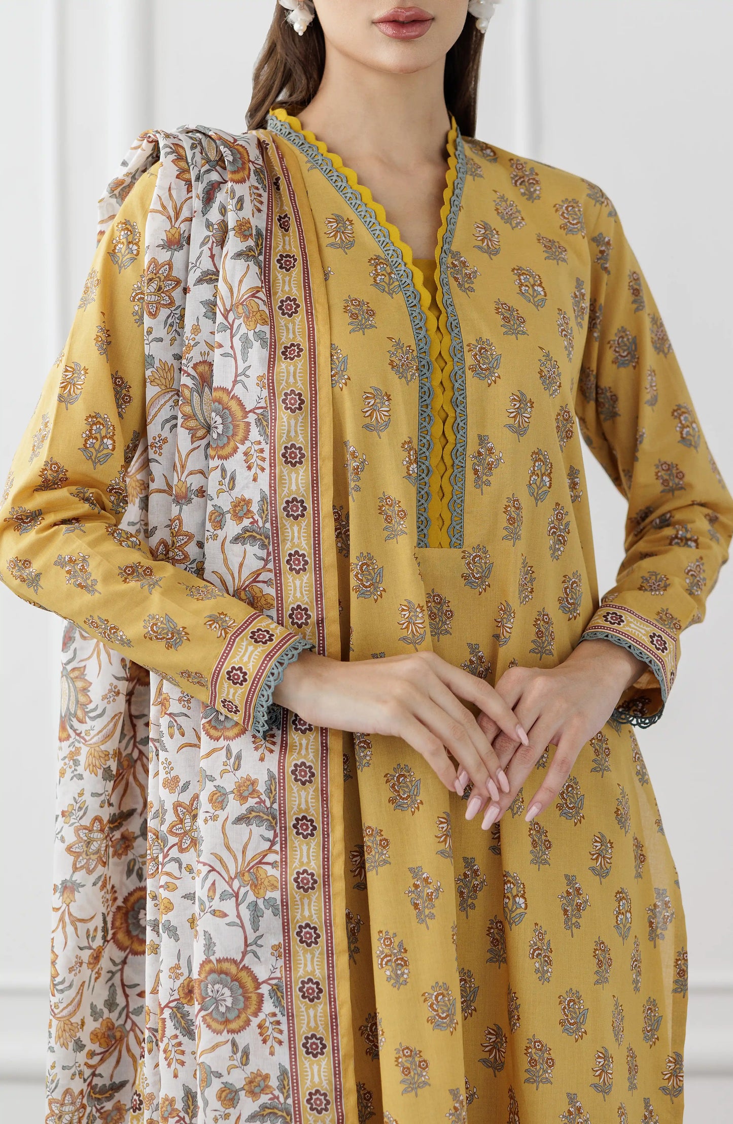 Woman wearing a mustard yellow kurta with a floral dupatta against a dyed trouser. Unstitched Printed Lawn Shirt Dupatta & Pant - 3 Piece Suits - OTL-25-118