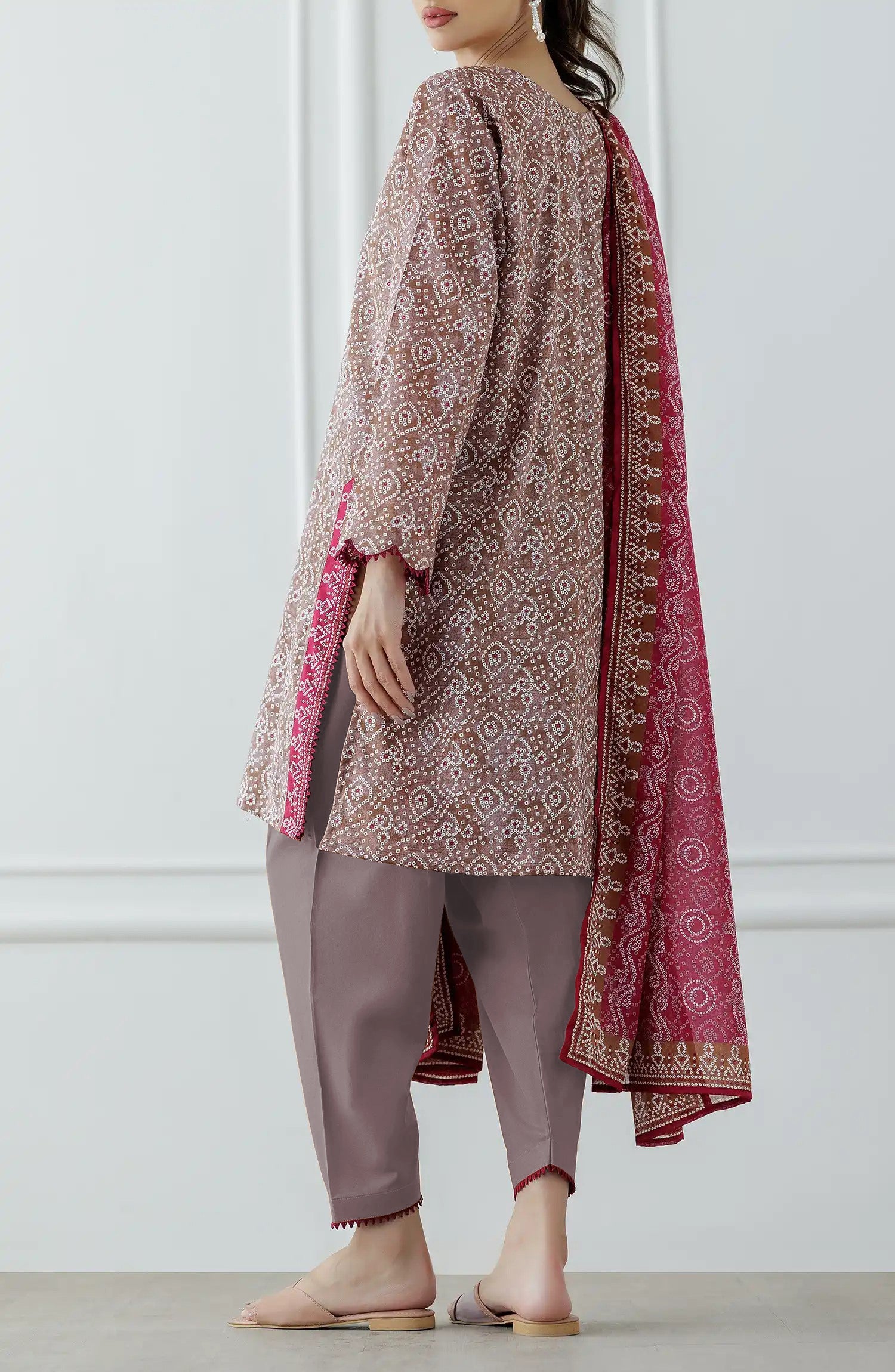 Woman wearing a patterned kurta with pants and a pink dupatta against a dyed trouser. Stitched Printed Lawn Shirt Dupatta & Pant - 3 Piece - OTL-25-308.