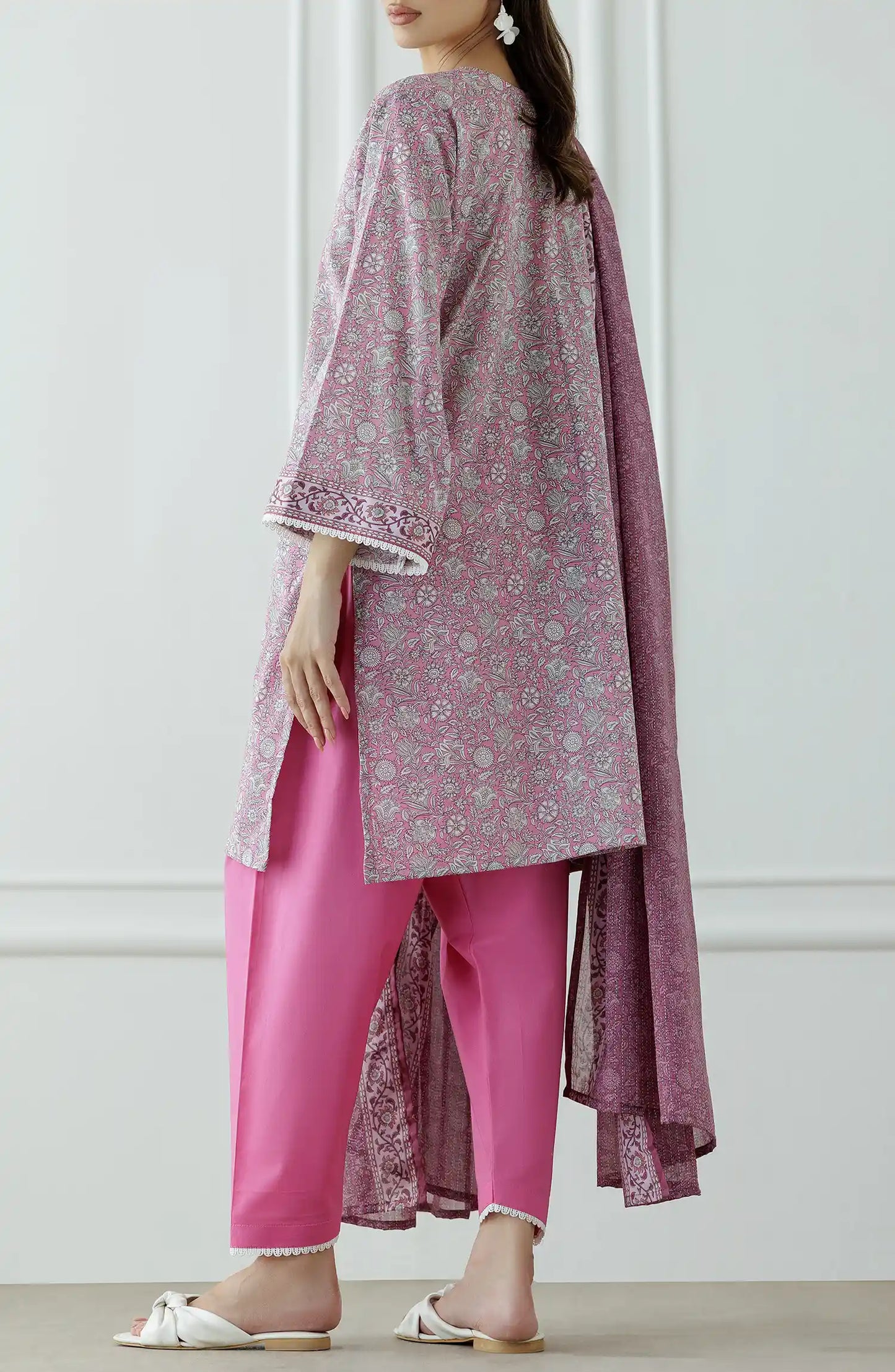 Woman wearing a pink traditional outfit with a matching dupatta against a matching traditional shalwar. Stitched Printed Lawn Shirt Dupatta & Pant - 3 Piece - OTL-25-309.
