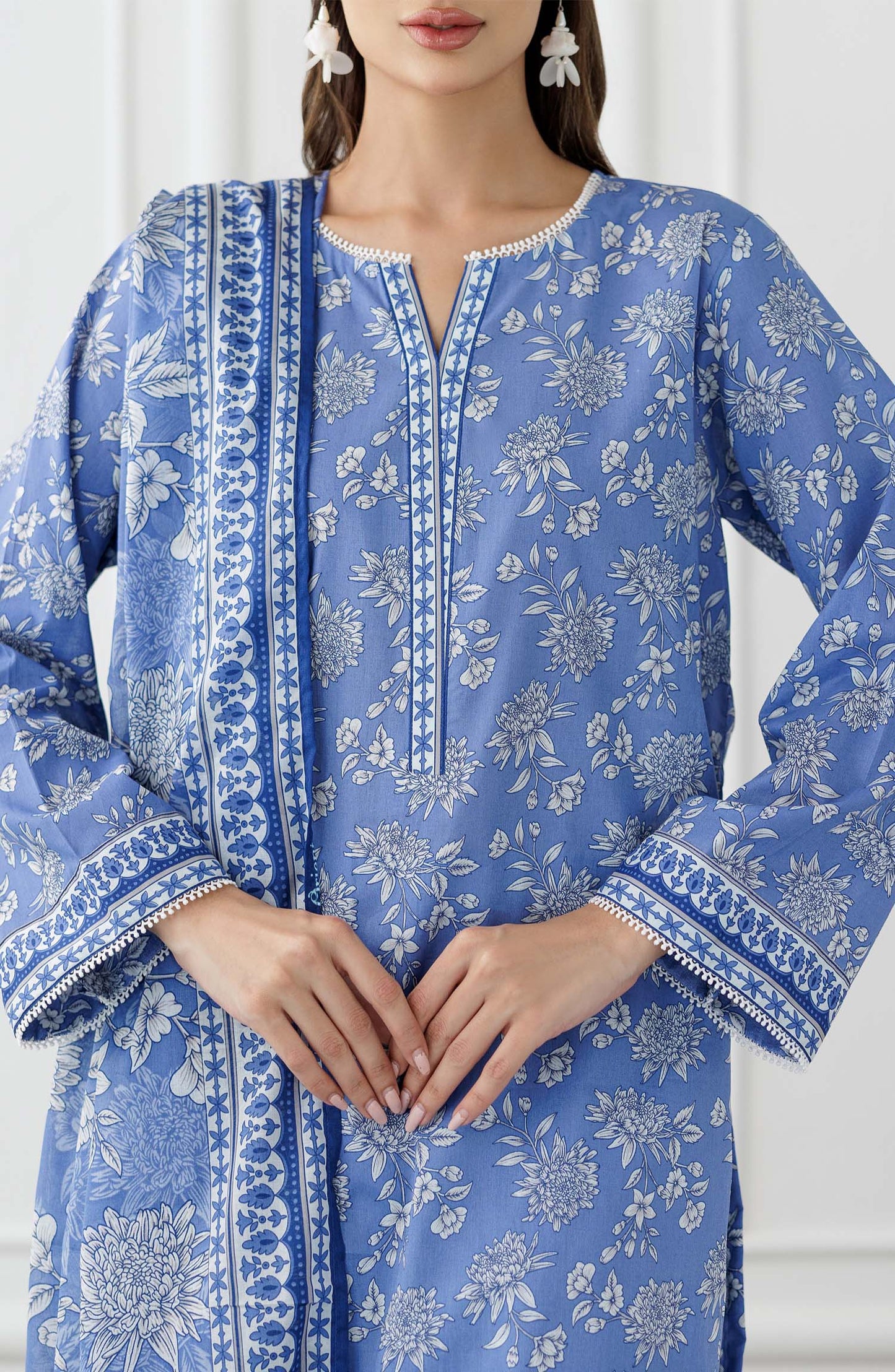 UNSTITCHED Printed Lawn Shirt Dupatta & Pant - 3 Piece Suits - OTL-25-338. Woman wearing a blue floral outfit with a matching dupatta and dyed trouser.