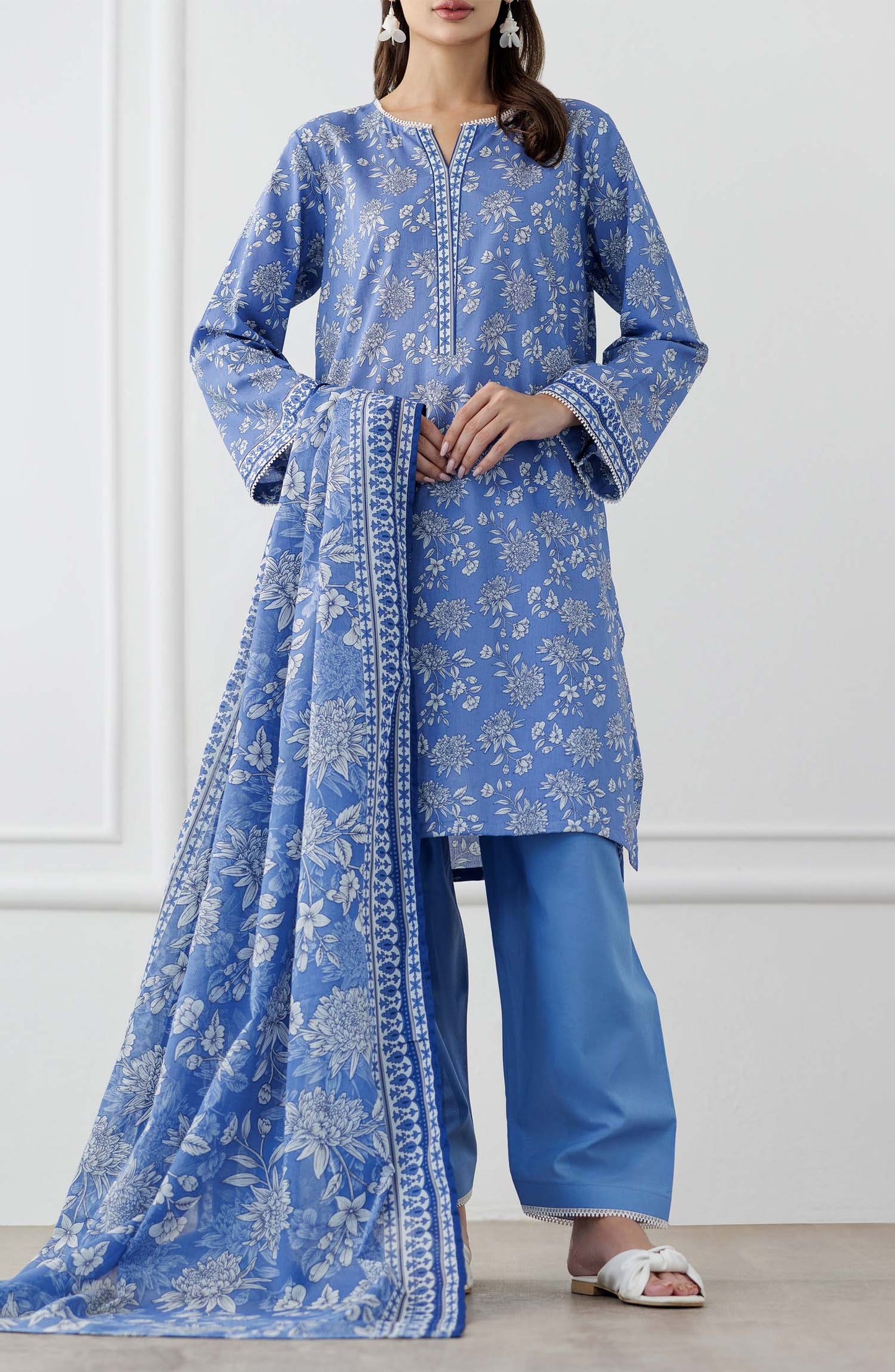 UNSTITCHED Printed Lawn Shirt Dupatta & Pant - 3 Piece Suits - OTL-25-338. Woman wearing a blue floral outfit with a matching dupatta and dyed trouser.