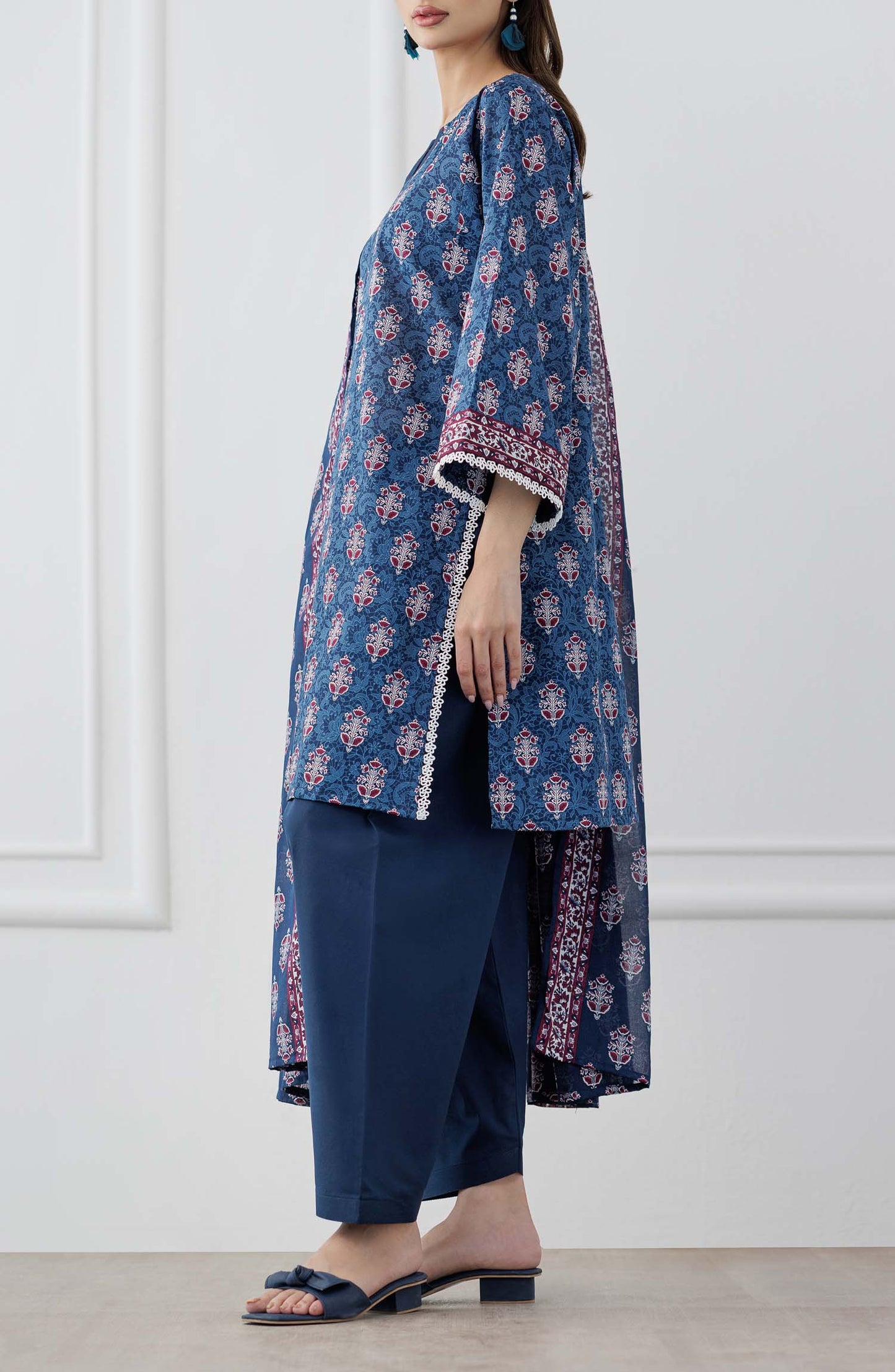 UNSTITCHED Printed Lawn Shirt Dupatta & Pant - 3 Piece Suits - OTL-25-353. Woman wearing a blue patterned kurta with matching pants and a dupatta against a plain trouser.