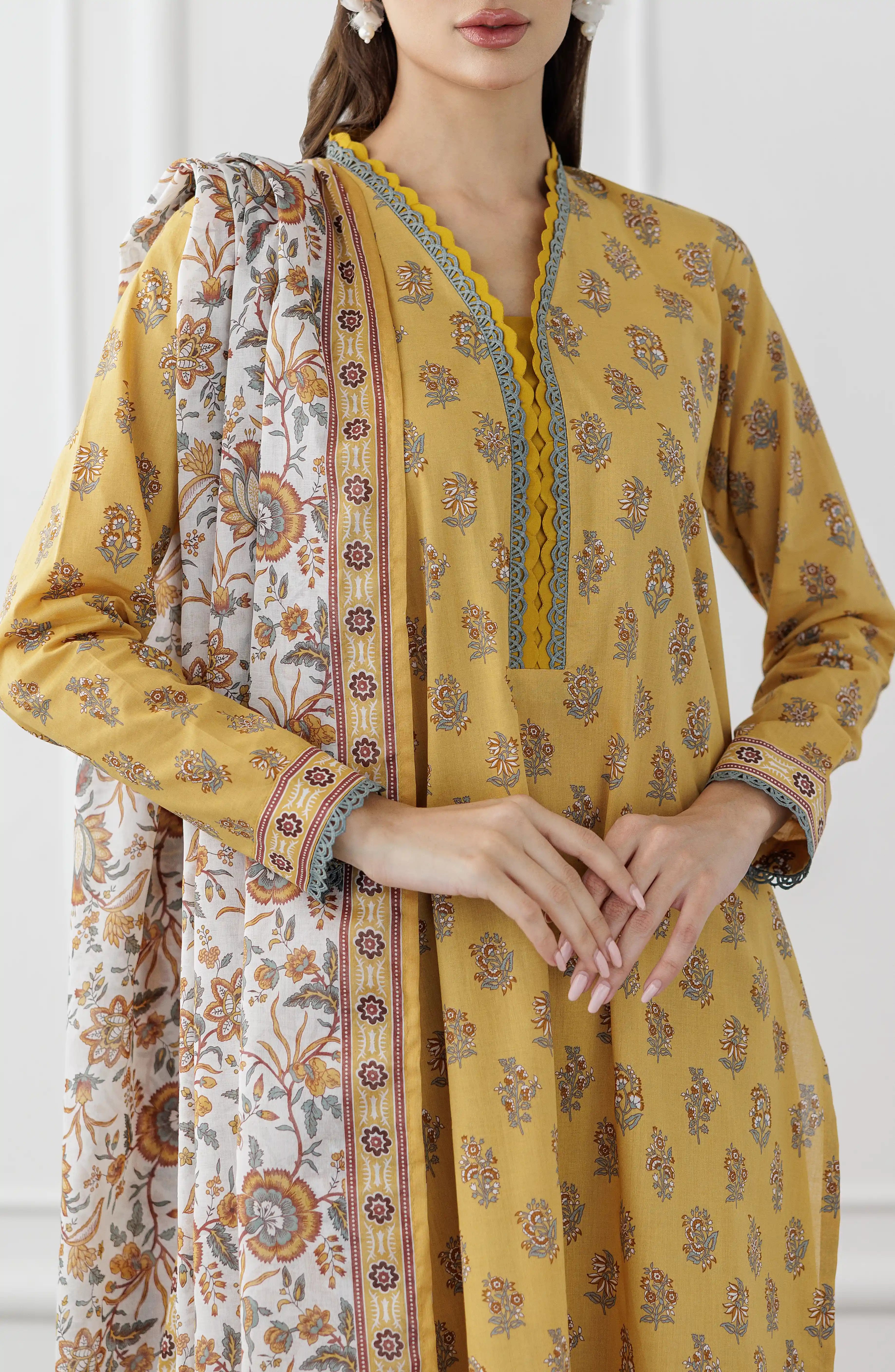 Woman wearing a mustard yellow kurta with a floral dupatta against a dyed trouser. Unstitched Printed Lawn Shirt Dupatta & Pant - 3 Piece Suits - OTL-25-118